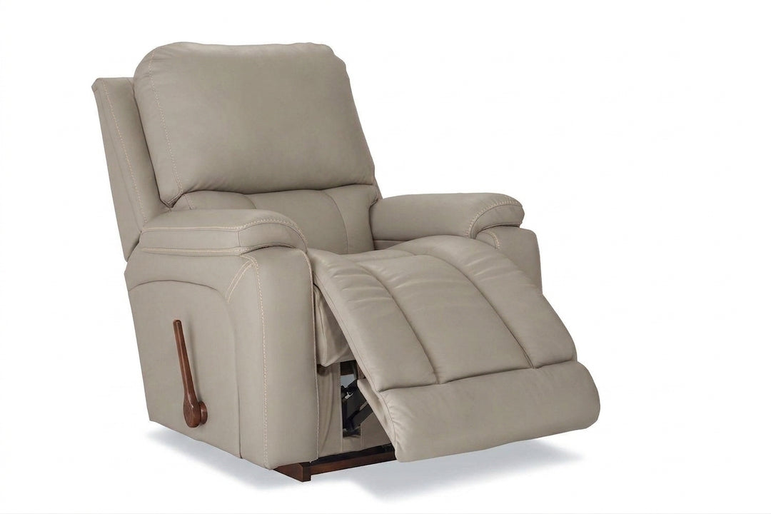 Light cream leather rocker recliner with padded arms and reclining footrest