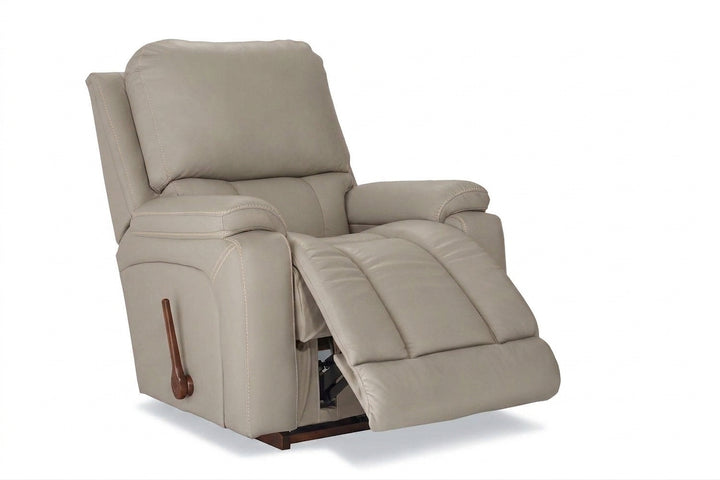 Light cream leather rocker recliner with padded arms and reclining footrest