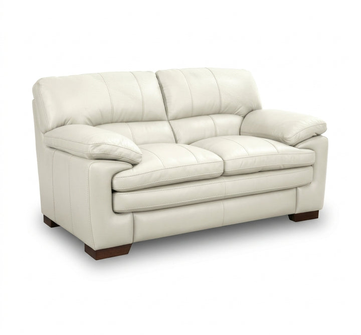 Light cream leather loveseat with padded arms, tufted back cushions, and cushioned seat