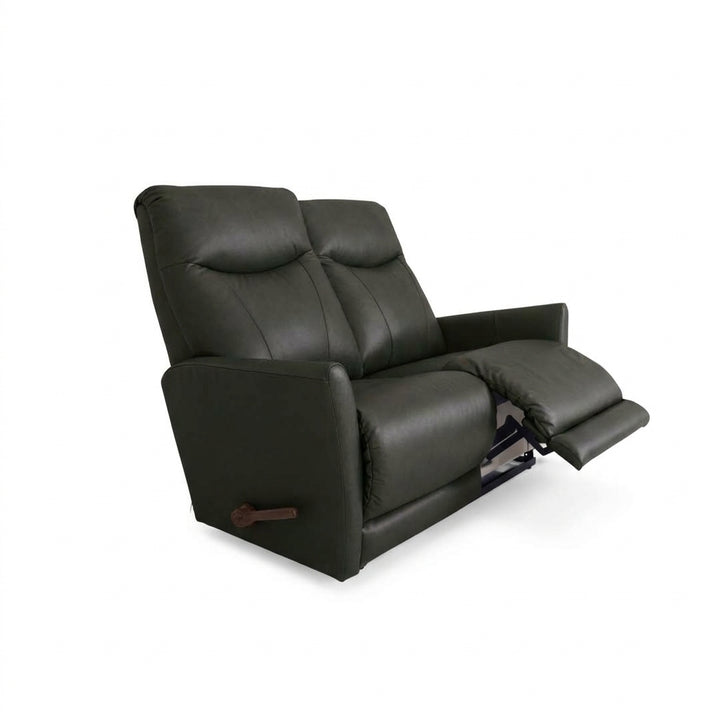 Black leather motion reclining loveseat with two padded headrests and pull tab handle