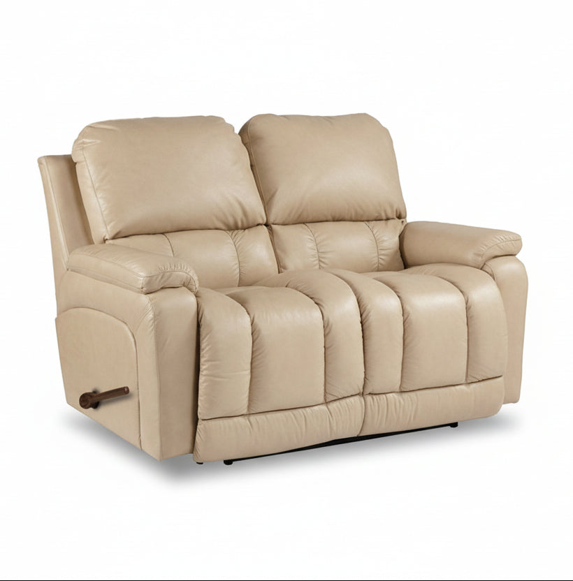 Light tan leather loveseat recliner with padded headrests and wide center console
