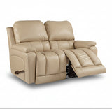 Light tan leather motion reclining loveseat with two padded seats and arm controls