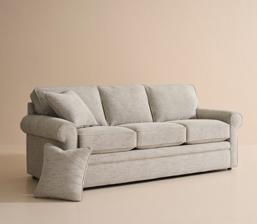 A softly cushioned neutral sofa in a warm home setting