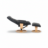 Black leather lounge chair on pedestal base with integrated ottoman footrest